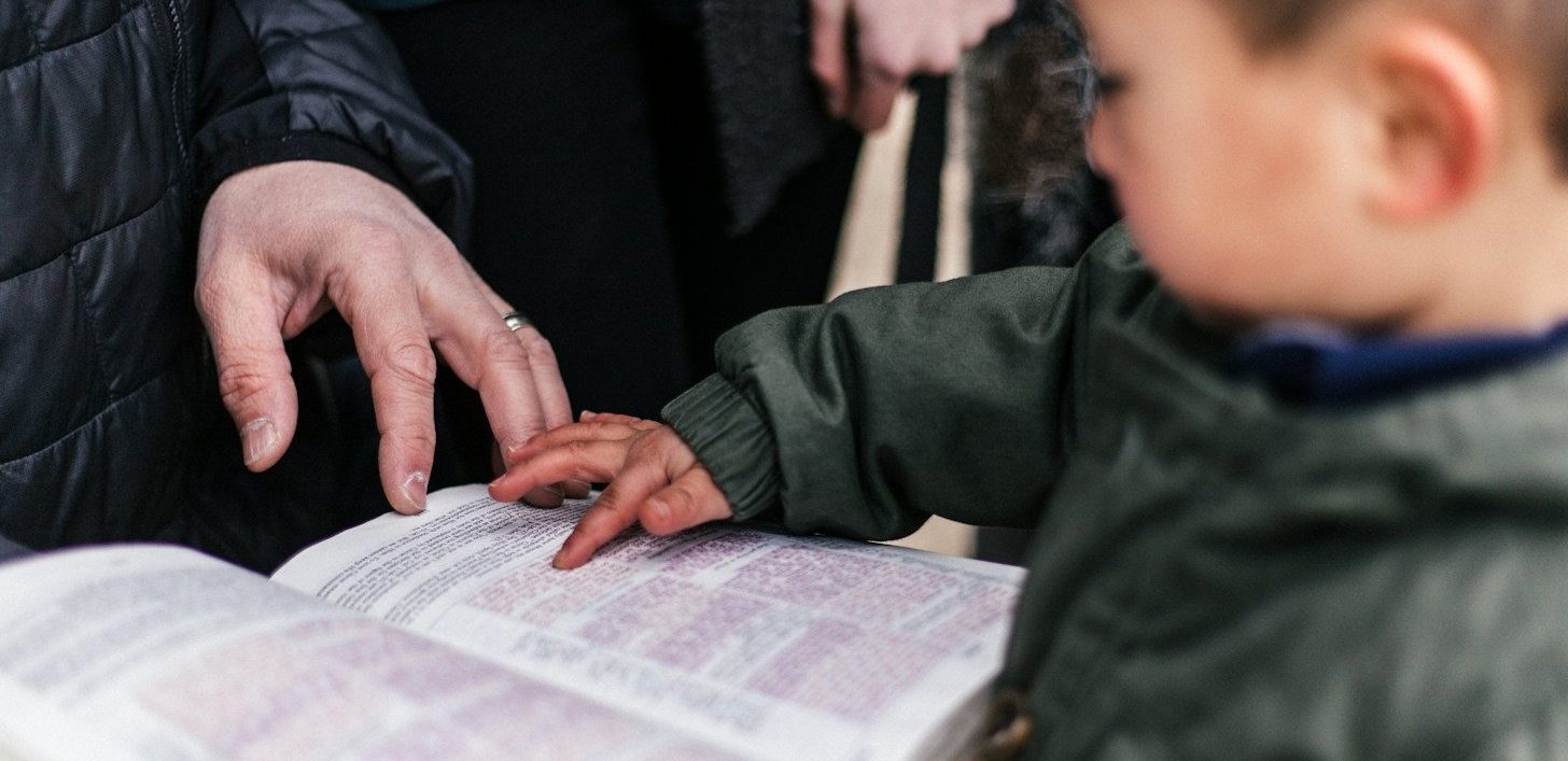 boy touching page of book
